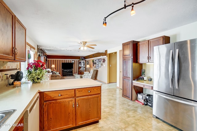 kitchen with open floor plan, light countertops, ceiling fan, freestanding refrigerator, and a peninsula