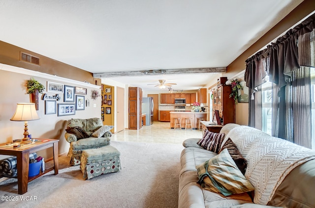 living area with light carpet, visible vents, beam ceiling, and a ceiling fan