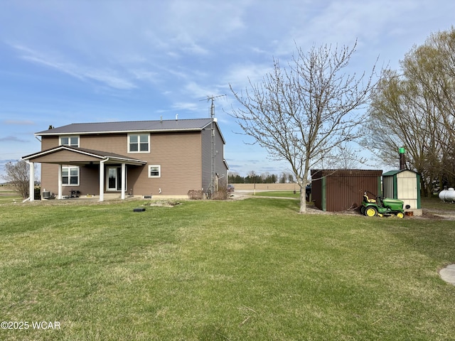 rear view of house featuring an outbuilding, a lawn, and a storage shed