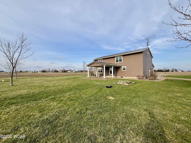 rear view of house featuring a lawn and a patio