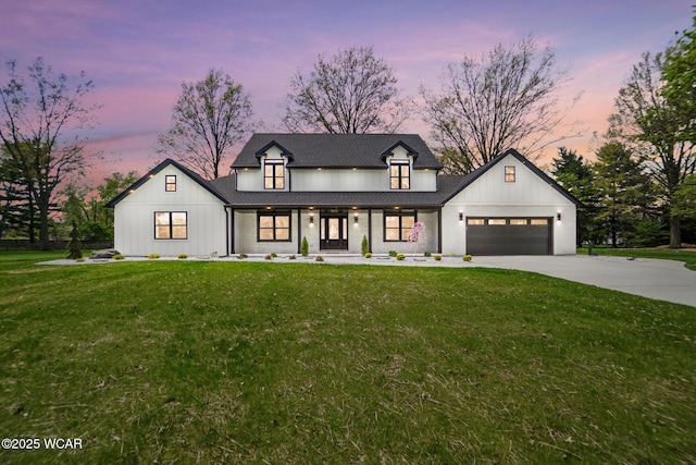 modern farmhouse style home featuring a garage, board and batten siding, a front yard, concrete driveway, and covered porch
