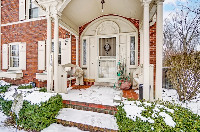 118 Boyd Ave, Van Wert, OH 45891 - snow covered property entrance featuring a porch and brick siding