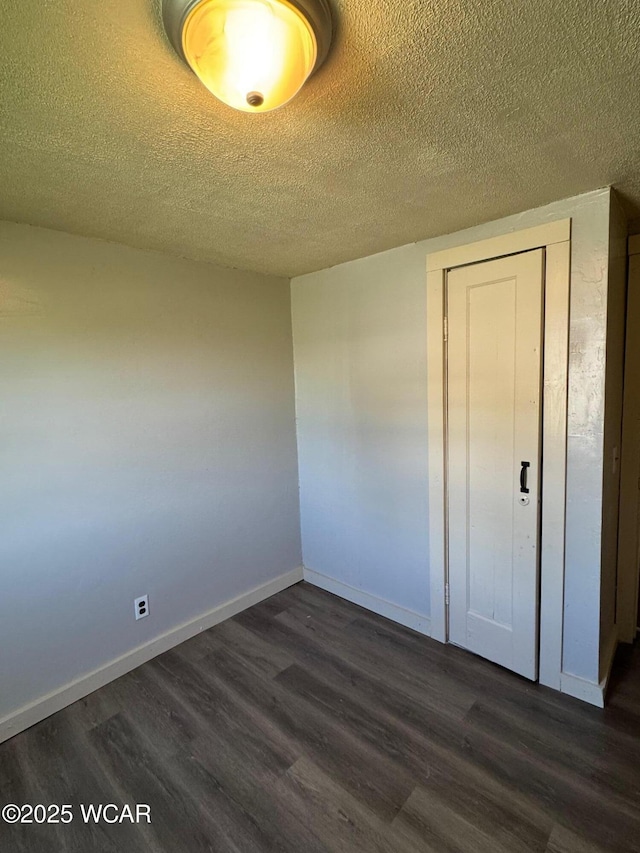 138 Letson Ave, Kenton, OH 43326 - unfurnished bedroom with dark wood-style floors, a textured ceiling, baseboards, and a closet