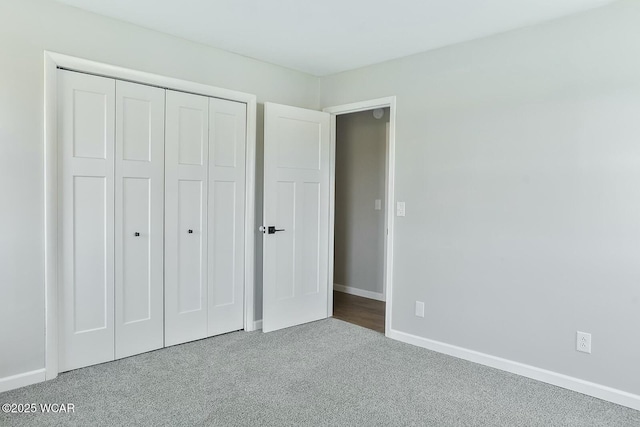 unfurnished bedroom with baseboards, a closet, and carpet