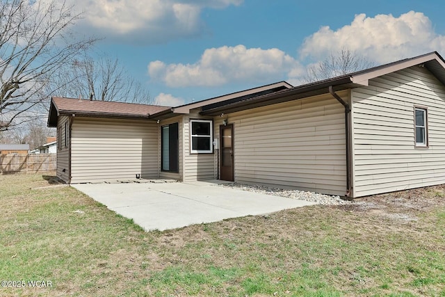 rear view of house featuring a lawn, fence, and a patio area