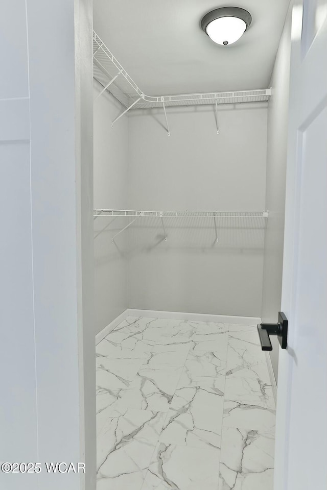 walk in closet with marble finish floor