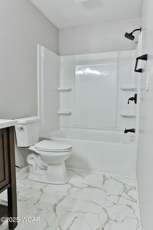 bathroom featuring marble finish floor, bathtub / shower combination, toilet, and vanity