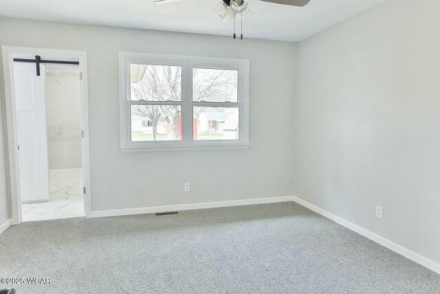 unfurnished bedroom featuring marble finish floor, baseboards, visible vents, and carpet flooring