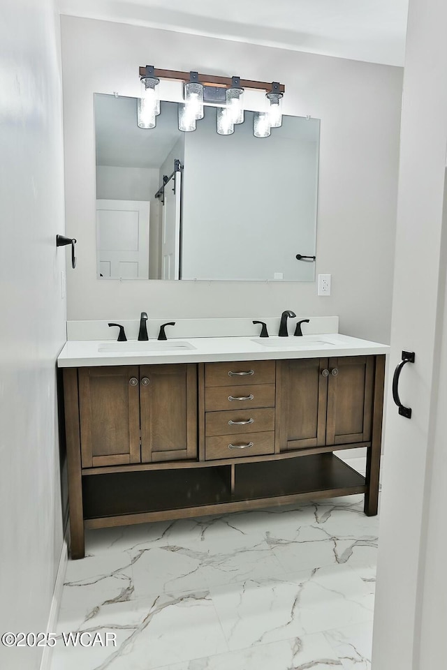 bathroom with marble finish floor, double vanity, and a sink