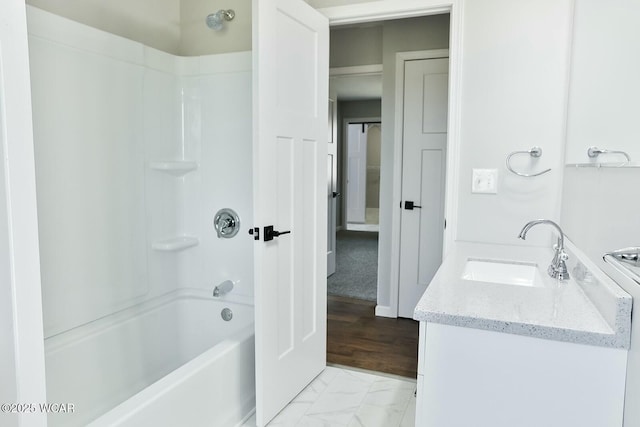 bathroom featuring marble finish floor, vanity, and shower / washtub combination