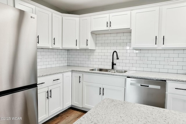 kitchen featuring a sink, backsplash, white cabinets, and appliances with stainless steel finishes