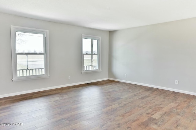 unfurnished room featuring baseboards and wood finished floors