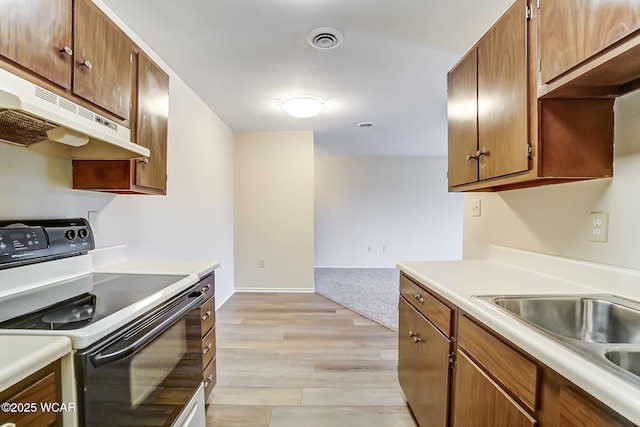 kitchen with sink, electric range, and light hardwood / wood-style floors