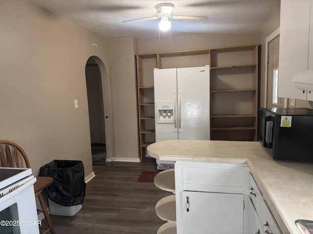 kitchen with white cabinets, white appliances, ceiling fan, dark wood-type flooring, and a textured ceiling