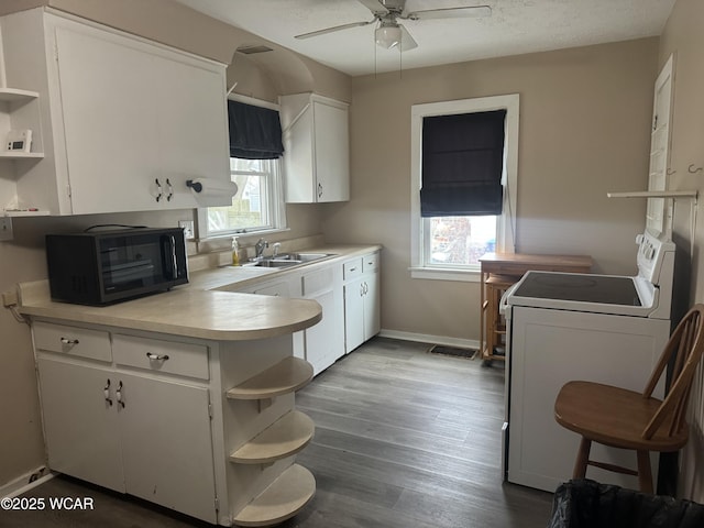 kitchen with dark hardwood / wood-style floors, sink, white cabinets, stove, and ceiling fan