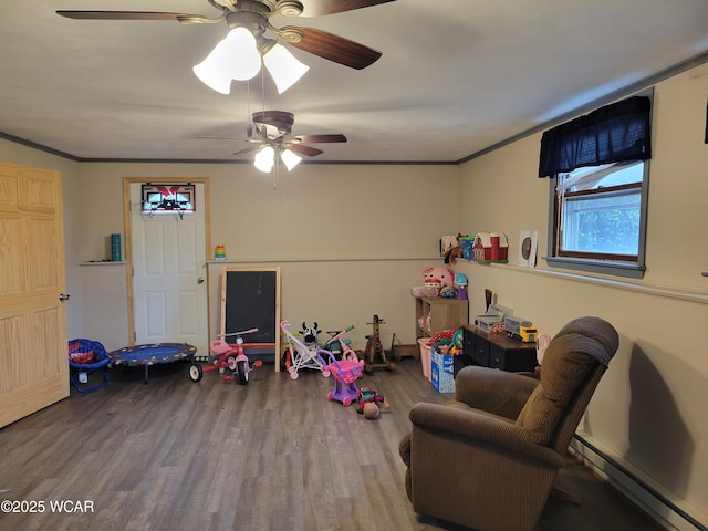 806 N Canal St, Delphos, OH 45833 - playroom featuring baseboard heating, wood finished floors, ceiling fan, and crown molding