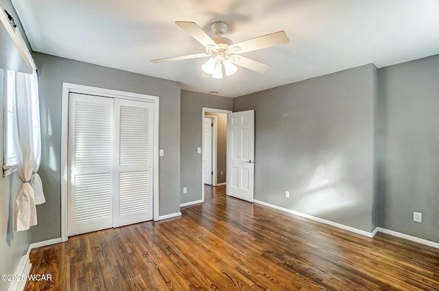 unfurnished bedroom with a closet, baseboards, wood finished floors, and a ceiling fan