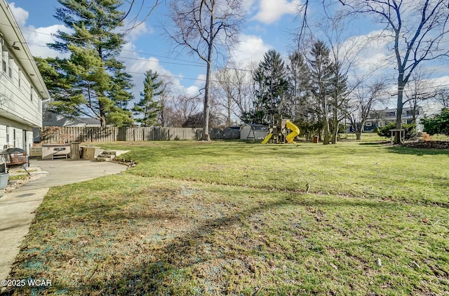 view of yard with a patio area, a playground, and a fenced backyard
