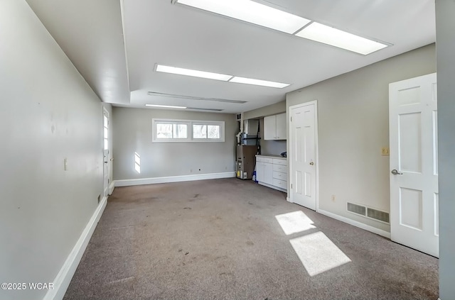 interior space with visible vents, light colored carpet, and baseboards