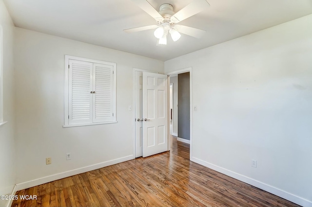 unfurnished bedroom featuring ceiling fan, baseboards, and wood finished floors