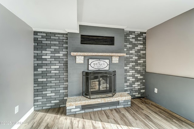 details featuring wood finished floors, a fireplace, and crown molding