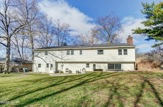 rear view of property with a yard, a chimney, and a patio area