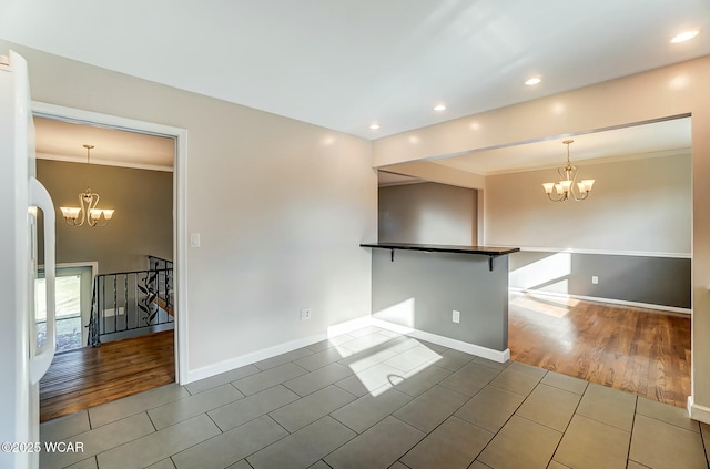 unfurnished room with tile patterned flooring, an inviting chandelier, and baseboards