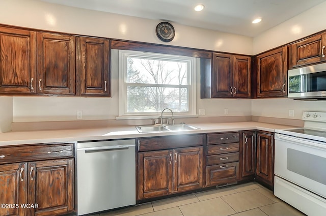 kitchen with light tile patterned floors, stainless steel appliances, light countertops, and a sink