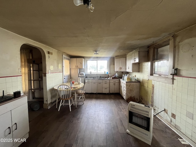 2845 Greely Chapel Rd, Lima, OH 45806 - kitchen with heating unit, arched walkways, dark wood-style flooring, a wainscoted wall, and white cabinets