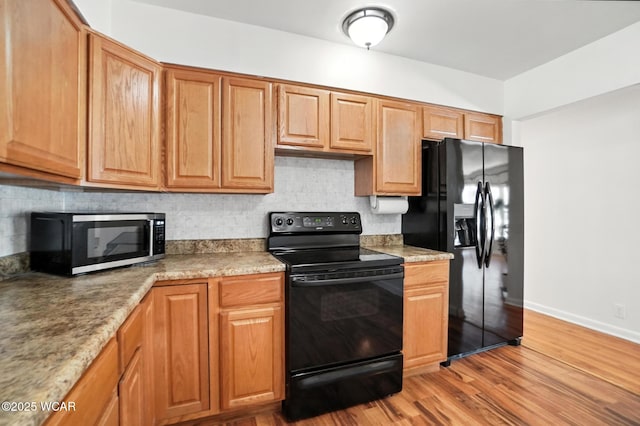 806 Tremont Ave, Lima, OH 45801 - kitchen featuring black appliances, tasteful backsplash, and light wood-style flooring
