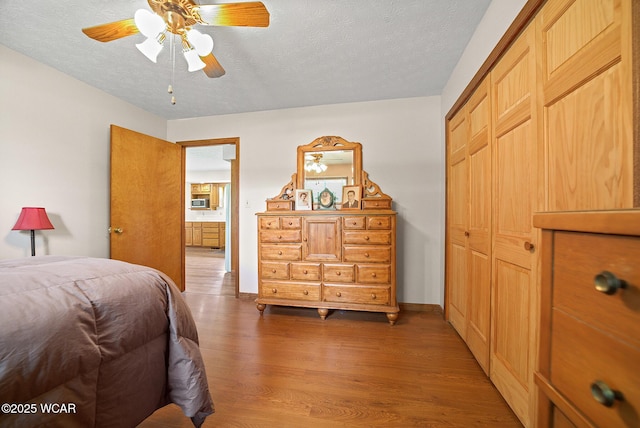 18509 State Highway 67, Upper Sandusky, OH 43351 - bedroom with wood finished floors, a textured ceiling, a closet, and ceiling fan