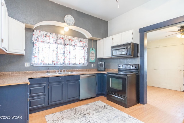 kitchen featuring white cabinets, blue cabinets, a sink, and black appliances