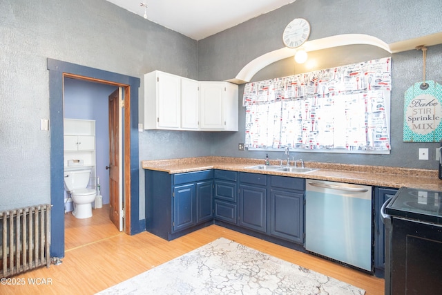 kitchen featuring light wood-type flooring, stainless steel dishwasher, a sink, and radiator