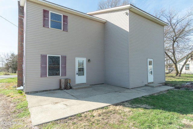 back of property featuring a patio area, entry steps, and a yard