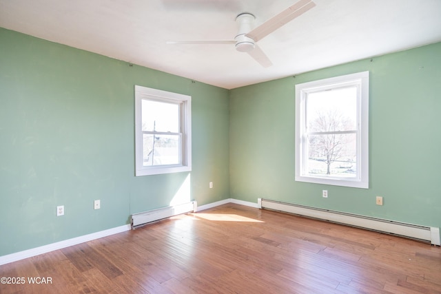 empty room featuring ceiling fan, baseboard heating, wood finished floors, and a baseboard radiator
