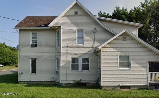 rear view of property featuring a yard