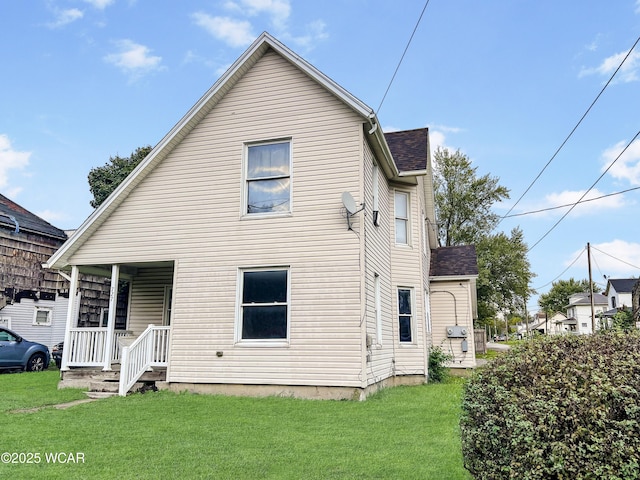 back of house featuring a yard and covered porch