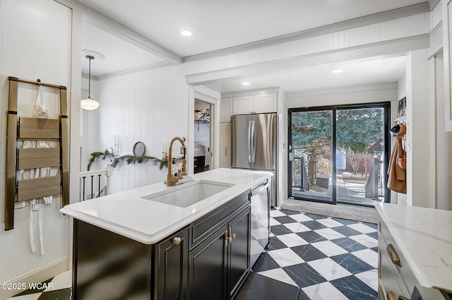 kitchen with sink, hanging light fixtures, stainless steel appliances, light stone counters, and an island with sink