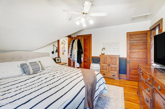 bedroom with vaulted ceiling, ceiling fan, and light hardwood / wood-style floors