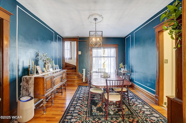 dining area featuring hardwood / wood-style floors and a notable chandelier