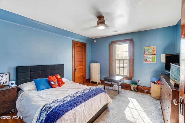 bedroom featuring radiator, light colored carpet, and ceiling fan