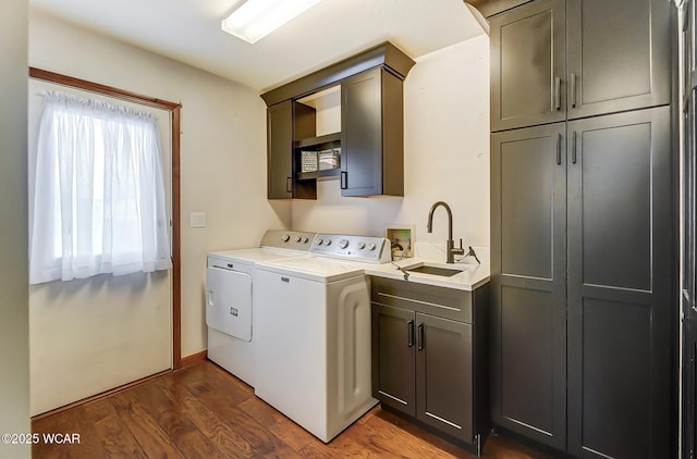 laundry area featuring cabinets, separate washer and dryer, sink, and dark wood-type flooring