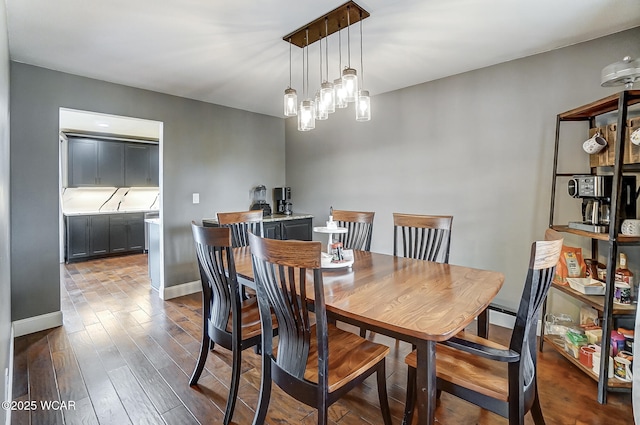 dining space featuring dark hardwood / wood-style flooring and a chandelier