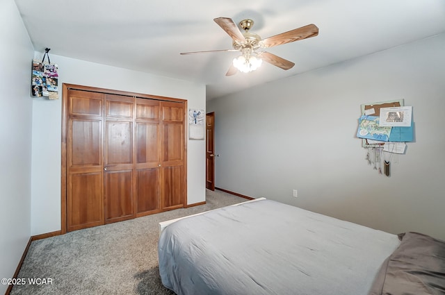 carpeted bedroom featuring ceiling fan and a closet