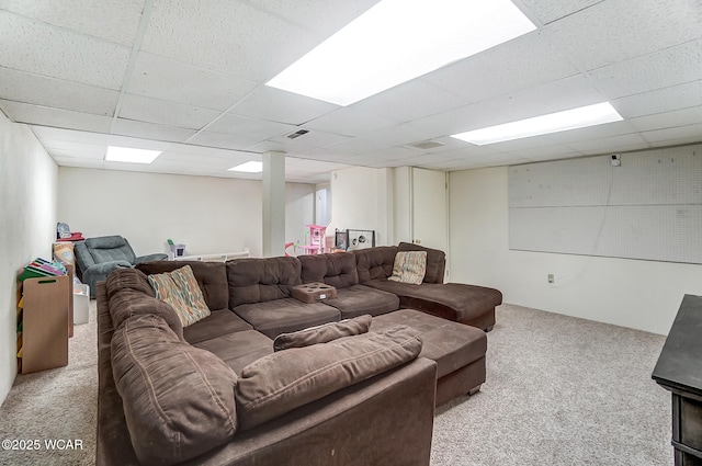 carpeted living room with a drop ceiling