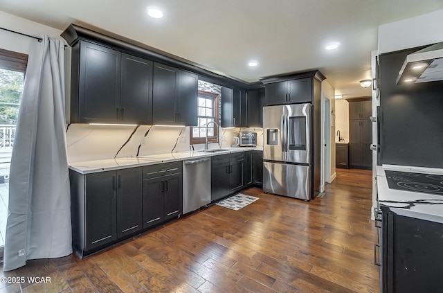 kitchen featuring light stone counters, stainless steel appliances, dark hardwood / wood-style floors, and sink