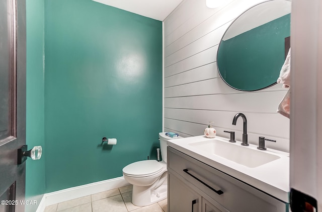 bathroom featuring tile patterned flooring, vanity, wood walls, and toilet