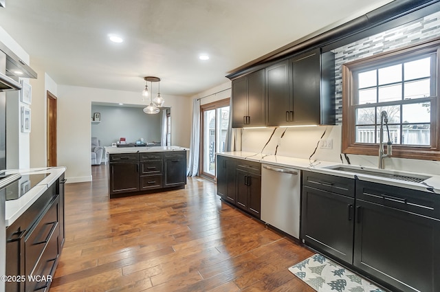 kitchen featuring sink, dark brown cabinets, hanging light fixtures, stainless steel dishwasher, and dark hardwood / wood-style flooring