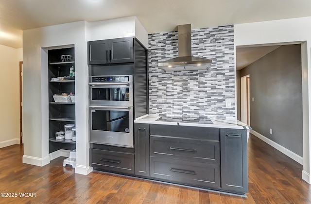 kitchen featuring dark wood-type flooring, wall chimney exhaust hood, double oven, black electric stovetop, and backsplash