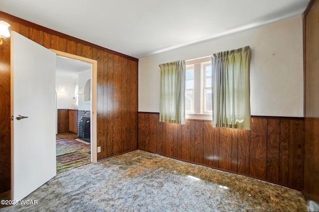 635 Close Ave, Lima, OH 45805 - unfurnished room featuring a wainscoted wall, wood walls, carpet floors, and arched walkways